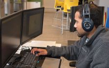 Young male works at computer station at Startup Zone PEI