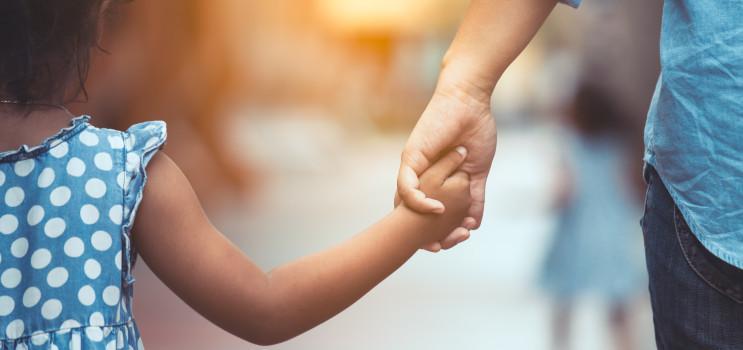 adult and child walking and holding hands