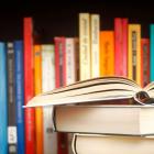 image of an open book in front of a library book shelf